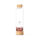 Elegante Glas-Trinkflasche von Lotus Vita mit Bambus-Akzenten und einem separaten Bodenfach, gefüllt mit Wassermelonen-Quarz und Amethyst-Kristallen.