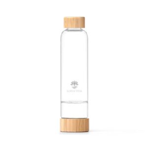 Elegante Glasflasche mit Bambusdeckel und einem separaten Fach im Boden, die auf einem weißen Hintergrund steht.
